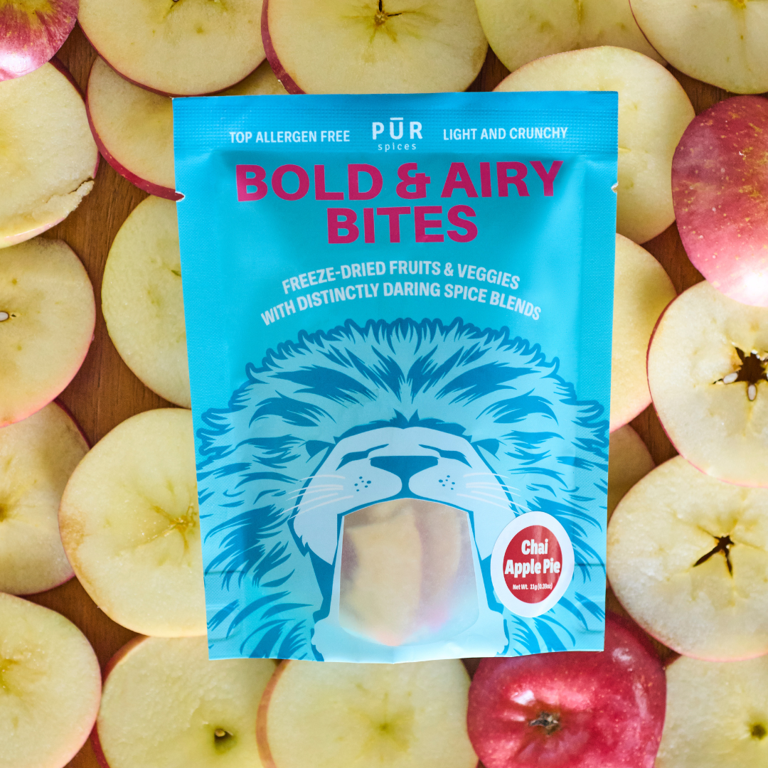 Package of  Chai Apple Pie Bold & Airy Bites' on a background of sliced apples.